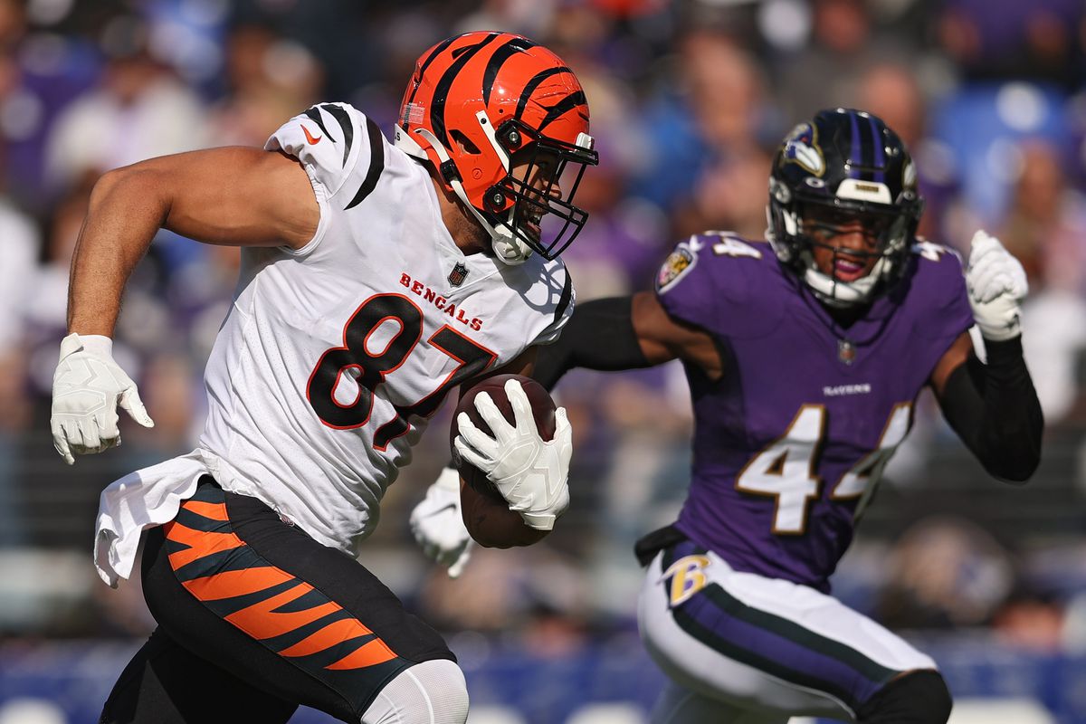 C.J. Uzomah #87 of the Cincinnati Bengals rushes with the ball before scoring a touchdown as Marlon Humphrey #44 of the Baltimore Ravens defends during the second quarter at M&amp;T Bank Stadium on October 24, 2021 in Baltimore, Maryland.