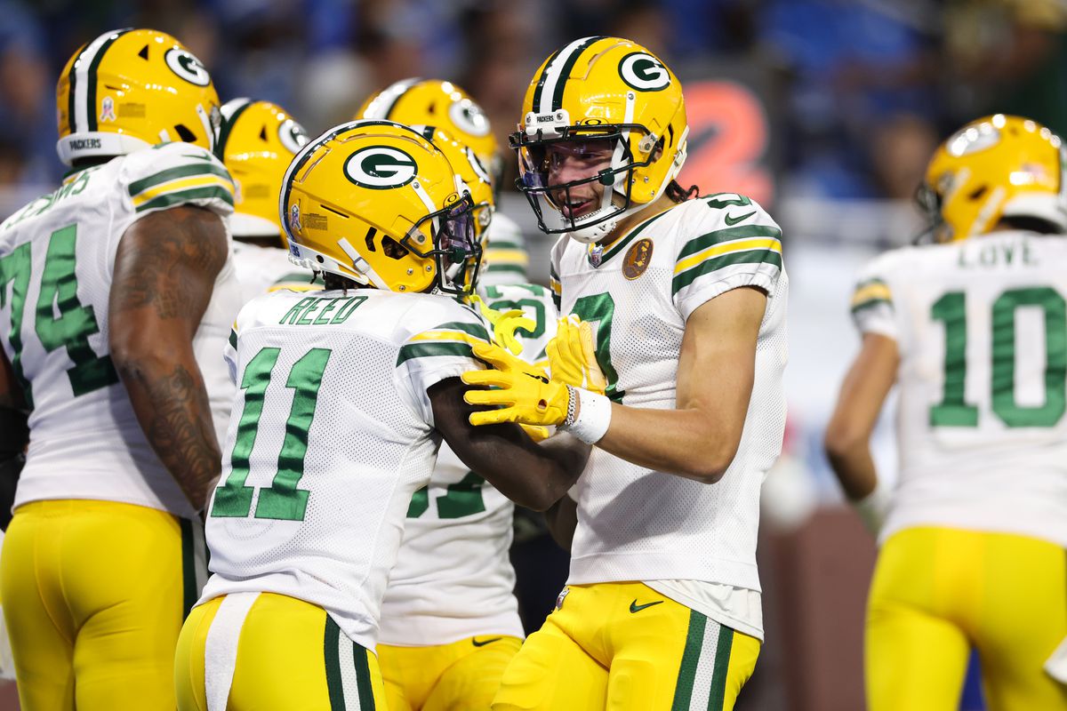 DETROIT, MICHIGAN - NOVEMBER 23: Jayden Reed #11 of the Green Bay Packers celebrates with teammate Christian Watson #9 after scoring a touchdown against the Detroit Lions during the first quarter of the game at Ford Field on November 23, 2023 in Detroit, Michigan.