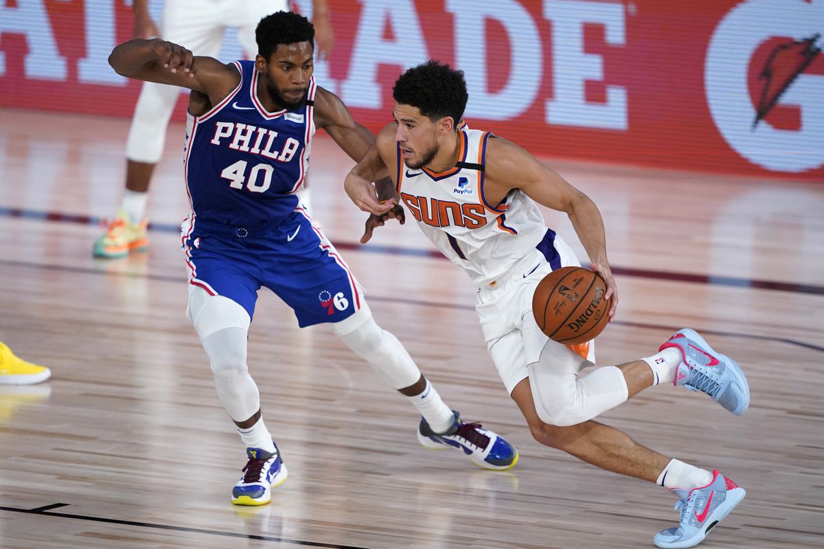 Phoenix Suns guard Devin Booker (1) drives past Philadelphia 76ers forward Glenn Robinson III (40) during the first half of an NBA basketball game Tuesday, Aug. 11, 2020, in Lake Buena Vista, Fla.&nbsp;