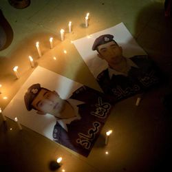 Members of Al-Kaseasbeh, the tribe of Jordanian pilot, Lt. Muath al-Kaseasbeh, who is held by the Islamic State group militants, light candles by posters with his picture and Arabic that reads "we are all Muath," at the captured pilot's tribal gathering divan, in his home town of Karak, Jordan, Saturday, Jan. 31, 2015. An online video released Saturday night purported to show an Islamic State group militant behead Japanese journalist Kenji Goto, ending days of negotiations by diplomats to save the man. 