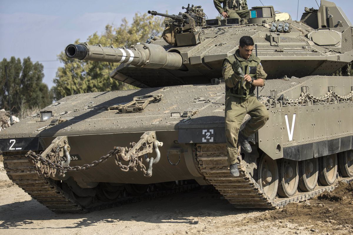 An Israeli soldier jumps off a tank near the Israel Gaza border, Tuesday, November, 13, 2018.&nbsp;