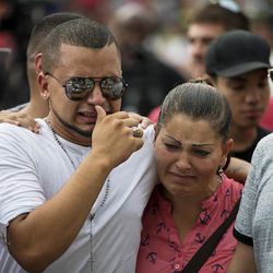 Victor Baez, left, cries with Iris Febo, as they mourn the loss of their friends Amanda Alvear and Mercedez Flores who were killed in the mass shooting at the Pulse nightclub, as they visit a makeshift memorial, Monday, June 13, 2016, in Orlando, Fla. A gunman killed dozens of people in a massacre at a crowded gay nightclub in Orlando on Sunday, making it the deadliest mass shooting in modern U.S. history. 