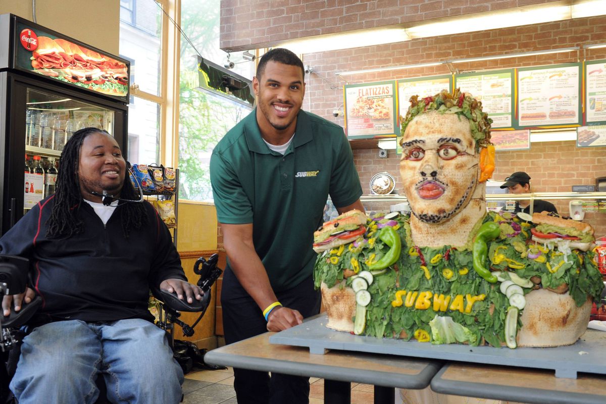 Eric LeGrand, left, SUBWAY Famous Fan and former Rutgers football player, looks on as Anthony Barr, 2014 draft prospect and newest SUBWAY Famous Fan, unveils a life-size food statue made of fresh vegetables, Wednesday, May 7, 2014, in New York. Barr 