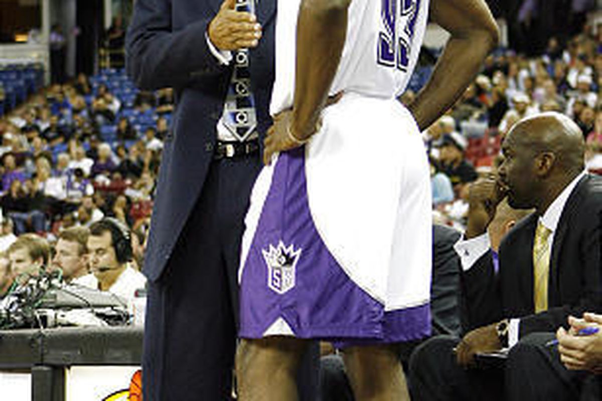 Sacramento Kings coach Reggie Theus counsels Ron Artest during a preseason game.
