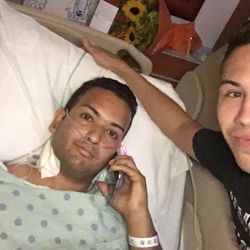 FILE - In this June 13, 2016 file photo released by Joseph Rivera, Felipe Marrero, left, poses in his hospital bed in Orlando, Fla., in this image taken by his friend Joseph Rivera, right. Marrero was shot four times in his back and left arm during last Sunday's attack on an Orlando nightclub. (Joseph Rivera via AP, File)