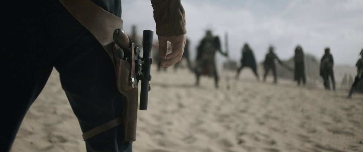 Alden Ehrenreich as Han Solo, training his hand over his blaster in a showdown.