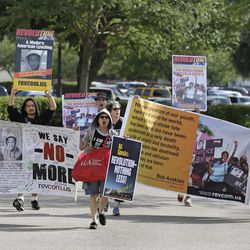 Members of the Revolutionary Communist Party, USA demonstrate outside the Seminole County Courthouse during the first day of trial for George Zimmerman, Monday, June 10, 2013, in Sanford, Fla. Zimmerman has been charged with second-degree murder for the 2012 shooting death of Trayvon Martin. (AP Photo/John Raoux)