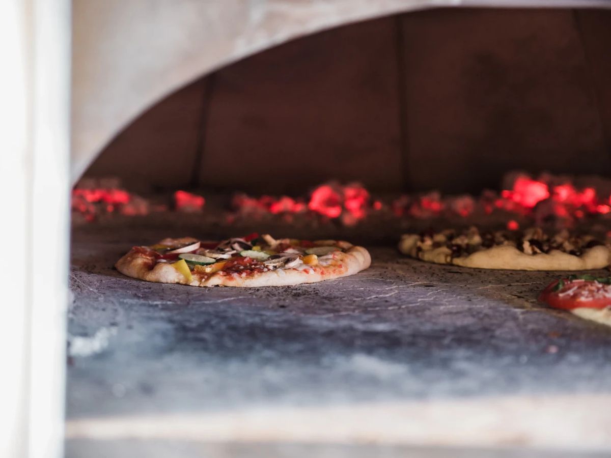 Three pizzas in a pizza oven. 