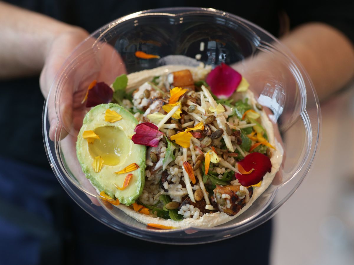 A person at Lulu Green holds a takeout bowl at the restaurant in Boston on Jan. 28, 2021.