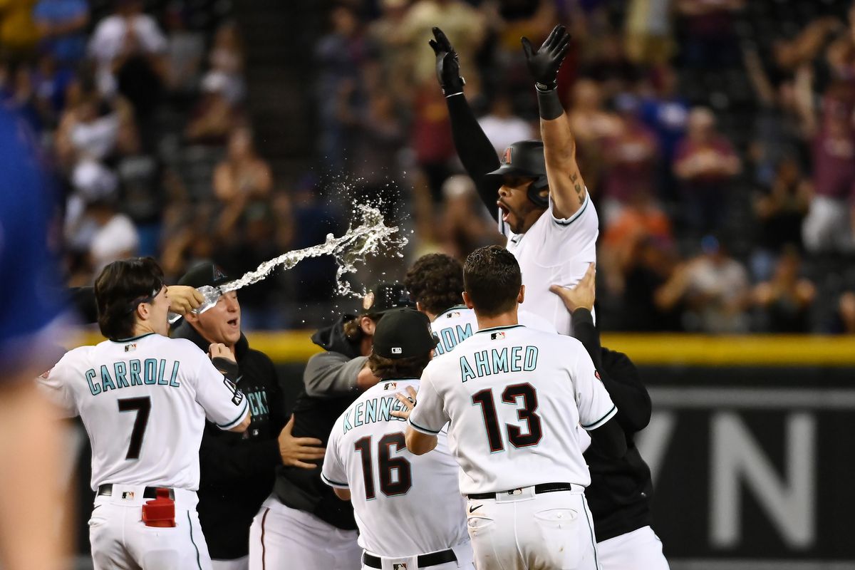Tommy Pham of the Arizona Diamondbacks celebrates with teammates after hitting a two run double to beat the Texas Rangers 4-3 in eleven innings at Chase Field on August 21, 2023 in Phoenix, Arizona.