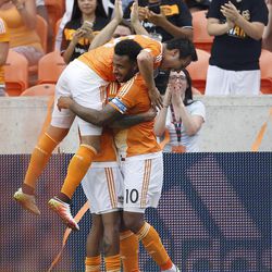 Houston Dynamo forward Erick Torres (9) jumps onto Giles Barnes (10) and Cristian Maidana (8) after Barnes scored a goal during the second half of a soccer game against Real Salt Lake at BBVA Compass Stadium, Sunday, May 15, 2016, in Houston.  Dynamo won the game 1-0. (Karen Warren/Houston Chronicle via AP)