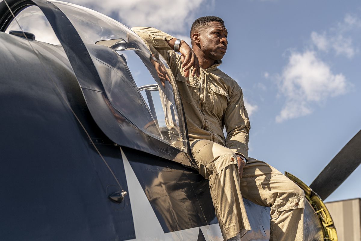 Navy pilot Jesse Brown (Jonathan Majors) sits on the rim of the cockpit of a fighter plane in Devotion