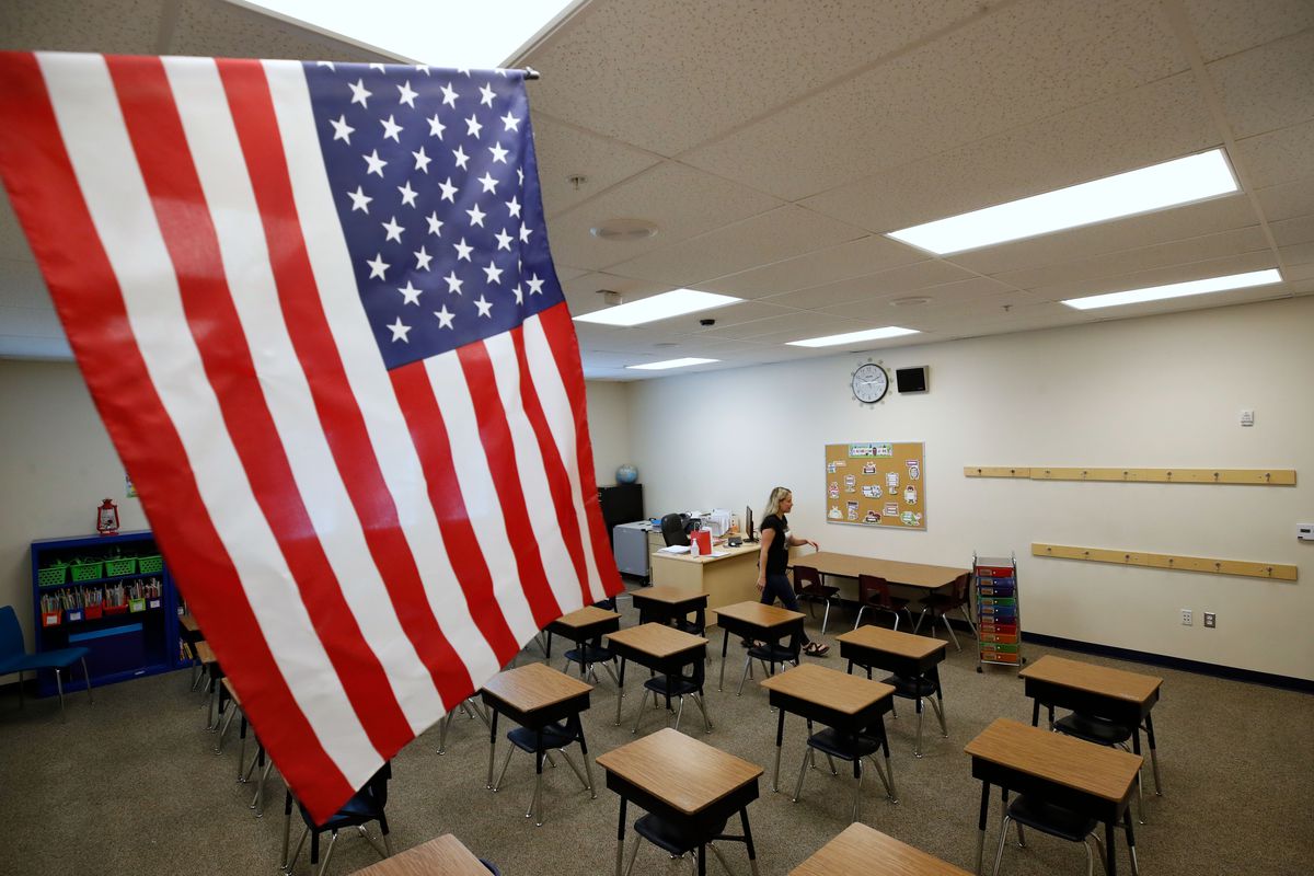 An empty schoolroom with a US flag.