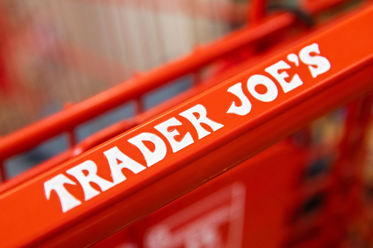The Trader Joe’s logo is written on a red shopping cart handle.