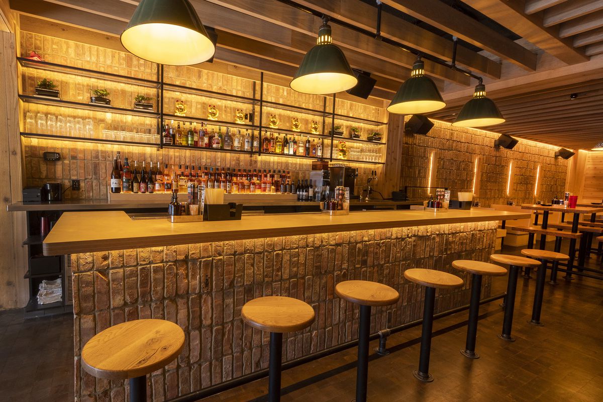 A stocked bar with stools.
