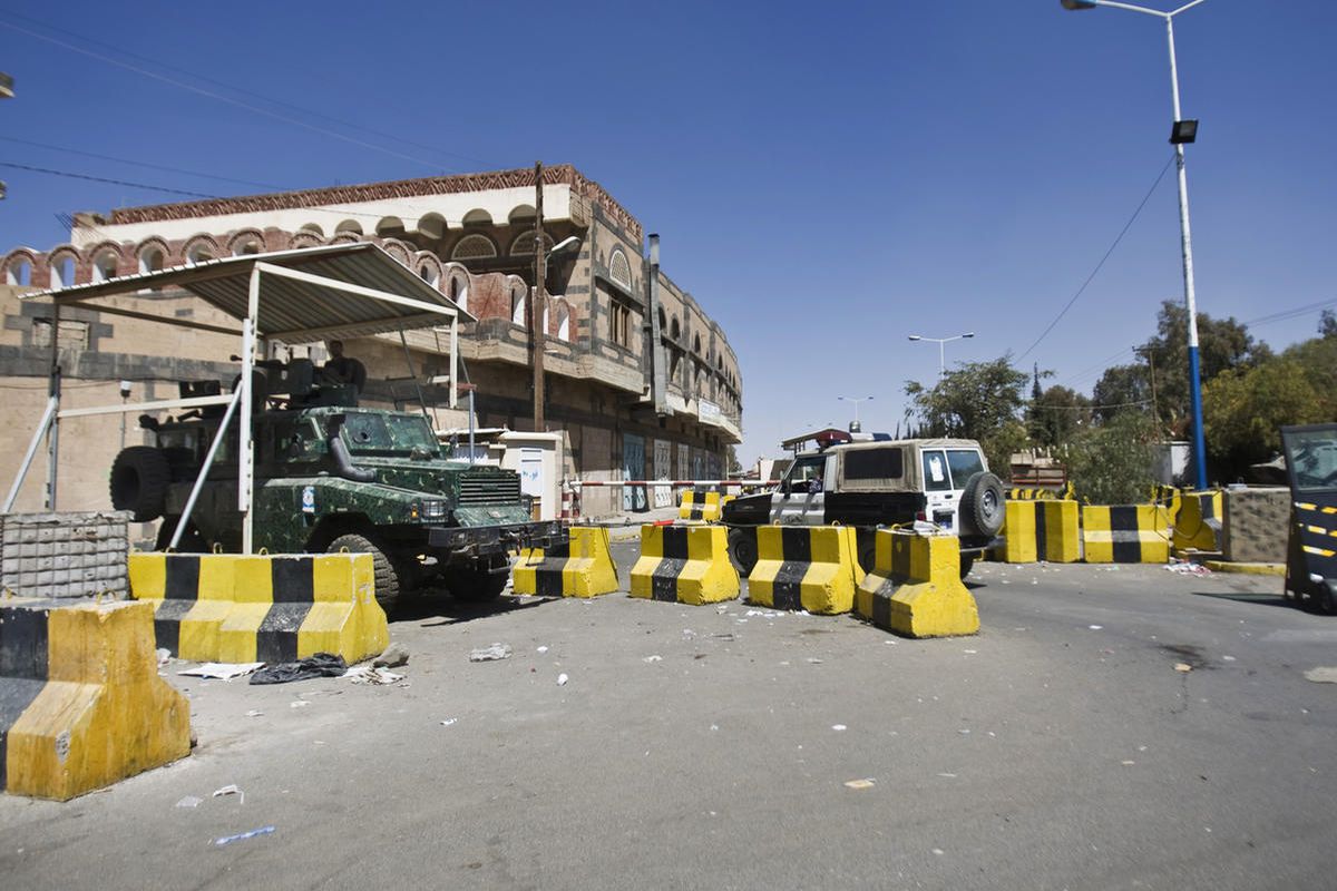 A policeman, left, mans a machine gun atop a military vehicle as he guards the entrance of the U.S. Embassy in Sanaa, Yemen, Wednesday, Feb. 11, 2015. 