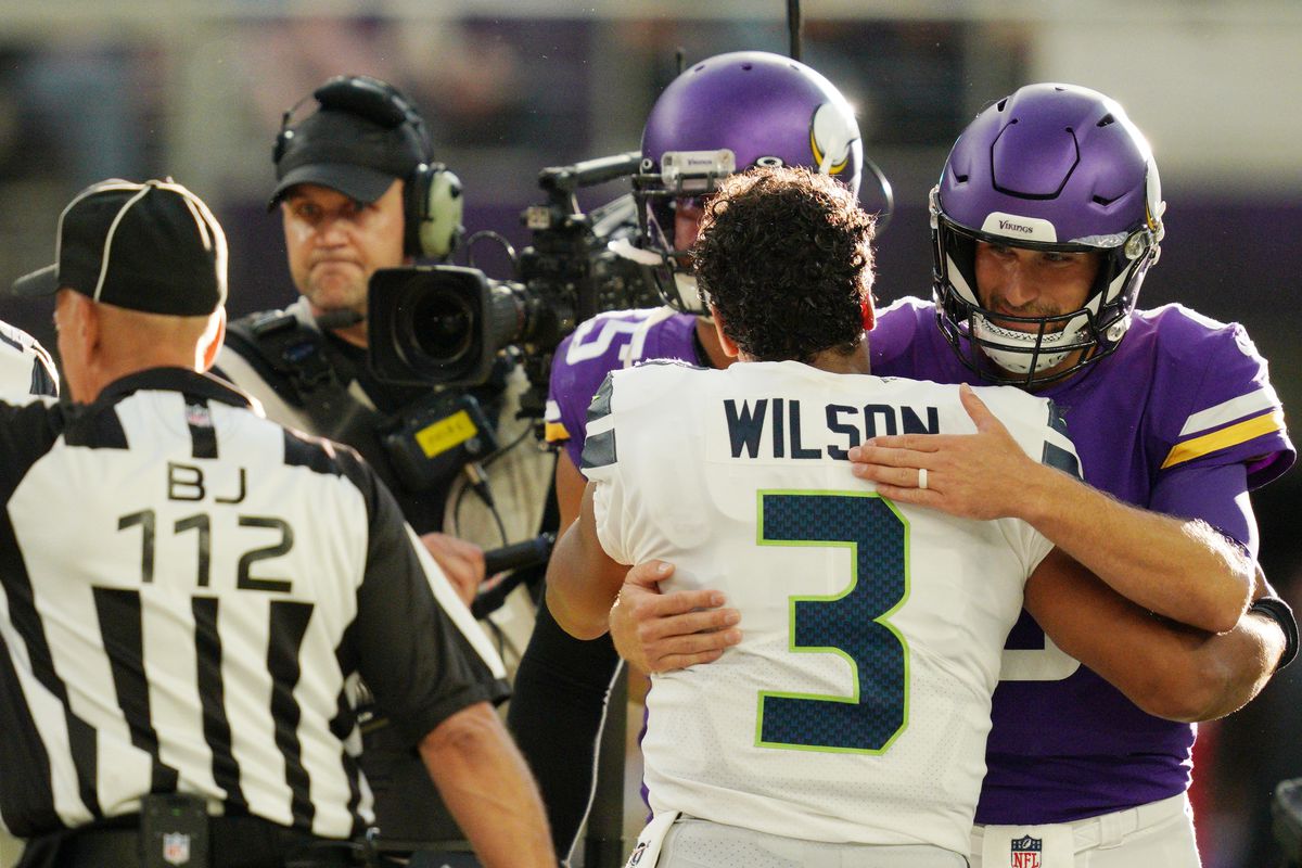 Minnesota Vikings&nbsp;quarterback Kirk Cousins and Seattle Seahawks quarterback Russell Wilson hug at the end of an NFL preseason football game.