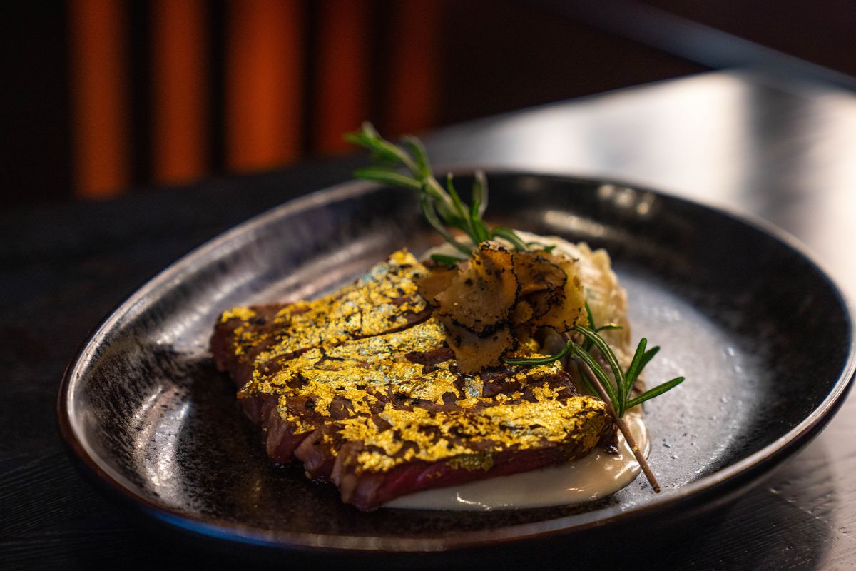 A strip steak covered in gold leaf at Mayflower Club.