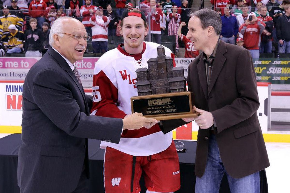 WCHA commissioner Bruce McLeod (left) presents the Broadmoor Trophy to Wisconsin's John Ramage.