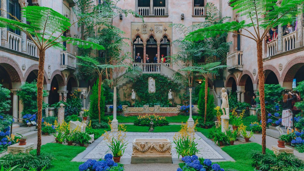 A lush and well-organized interior courtyard with lots of plants and grass.