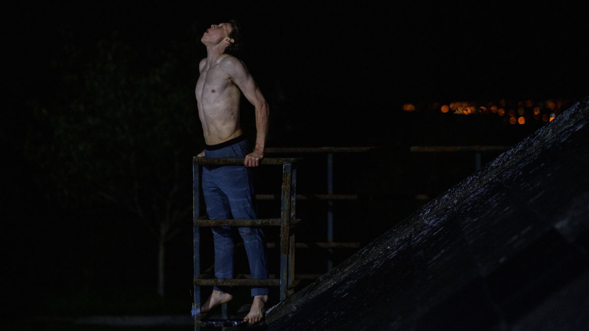 George MacKay, standing shirtless and barefoot at the edge of a parapet, howls at the moon in Wolf