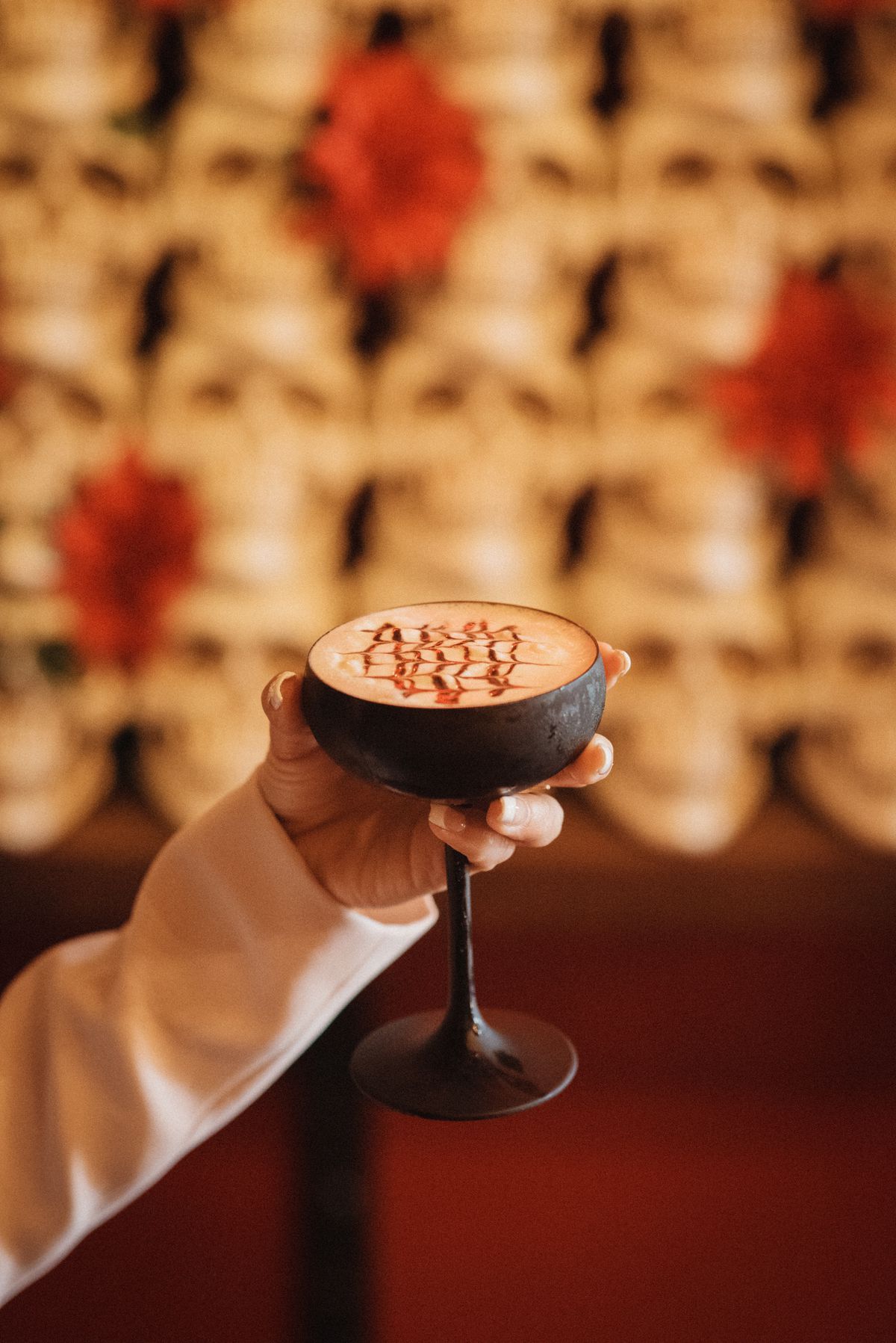 A cocktail in a coupe with bitters on top.