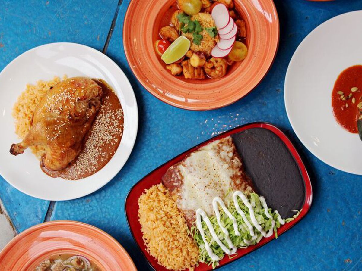 A photo from above of several Mexican dishes on plates at Que Bueno Suerte 