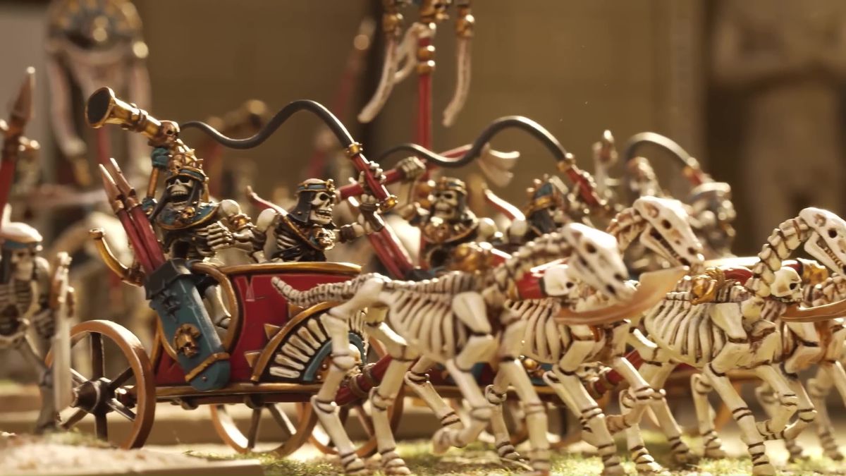 Skeletal horses tow skeletons in chariots in a scene from a YouTube promotional video from Games Workshop.