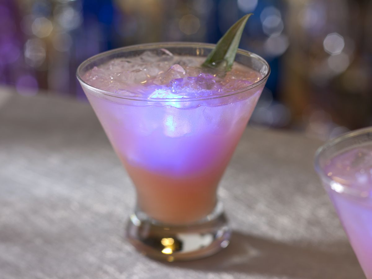 A glowing cocktail on a bar.