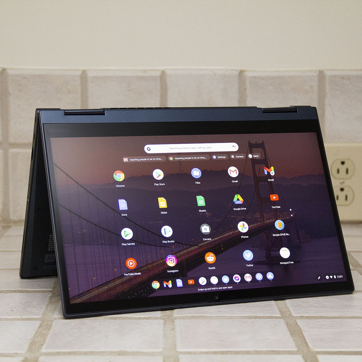 O Chromebook ThinkPad C13 Yoga no modo tenda.  A tela exibe uma grade de aplicativos Android.