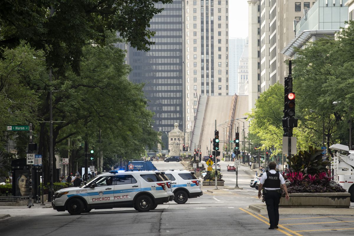 Chicago Police stand guard on the Magnificent Mile and the Michigan Avenue Bridge over the Chicago River is lifted after looting broke out overnight in the Loop and surrounding neighborhoods, Monday morning, Aug. 10, 2020. | 
