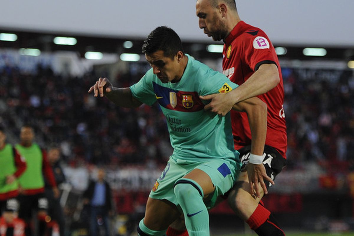  Alexis Sanchez of FC Barcelona (L) duels for the ball with Ivan Ramis of RCD Mallorca during the La Liga match between RCD Mallorca and FC Barcelona at Iberostar Stadium.
