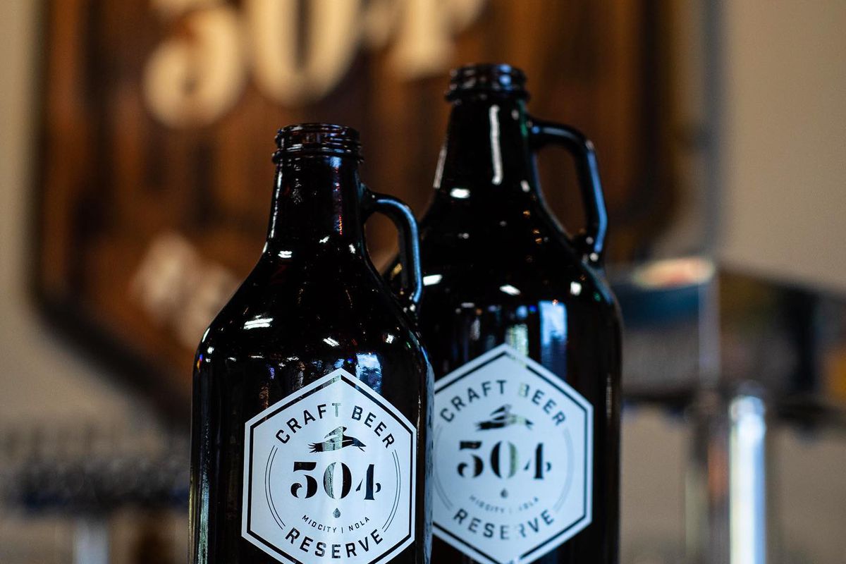 Two growlers with 504 Craft Beer Reserve labels sit on a bar.