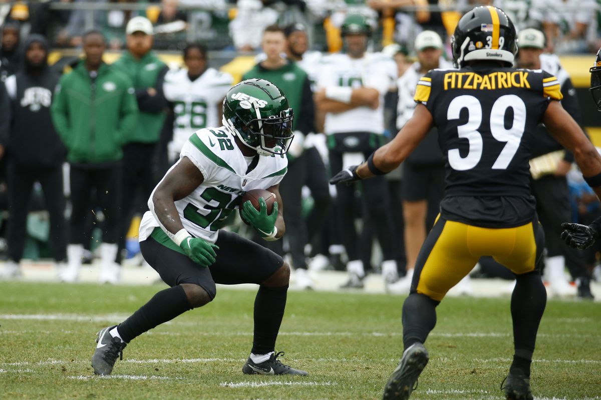 Michael Carter of the New York Jets runs with the ball while being chased by Minkah Fitzpatrick of the Pittsburgh Steelers in the first quarter at Acrisure Stadium on October 02, 2022 in Pittsburgh, Pennsylvania.