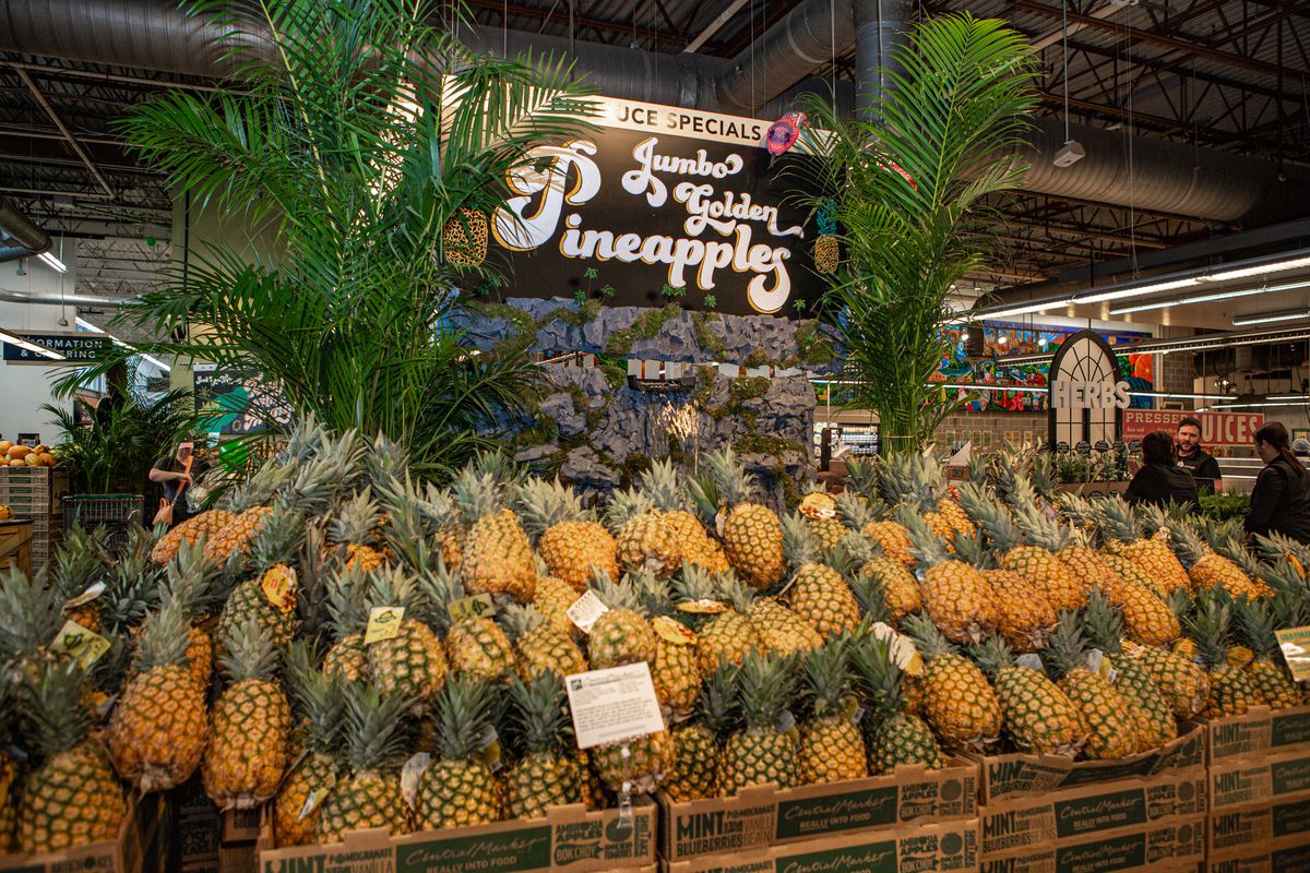 A large display of jumbo golden pineapples.