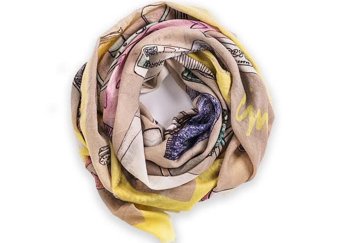 A rolled up scarf printed with hand-drawings by CJW.