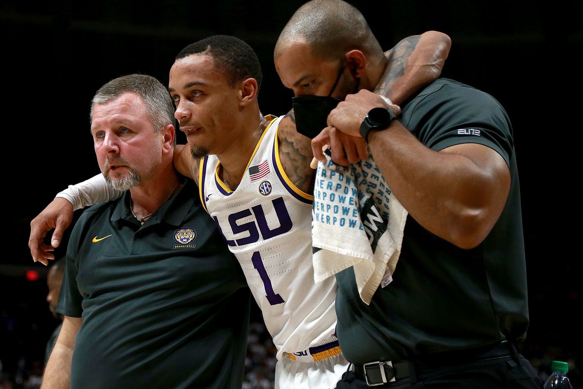Xavier Pinson of the LSU Tigers is helped off the court after injuring his right knee during the second half of a NCAA basketball game against the Tennessee Volunteers at Pete Maravich Assembly Center on January 08, 2022 in Baton Rouge, Louisiana.