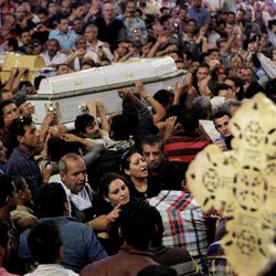 Egyptian Christians four coffins during a funeral service, at the Saint Mark Coptic cathedral in Cairo, Egypt, Sunday, April 7, 2013. Several Egyptians including 4 Christians and a Muslim were killed in sectarian clashes before dawn in Qalubiya, just outside of Cairo on Saturday, April 6, 2013. 