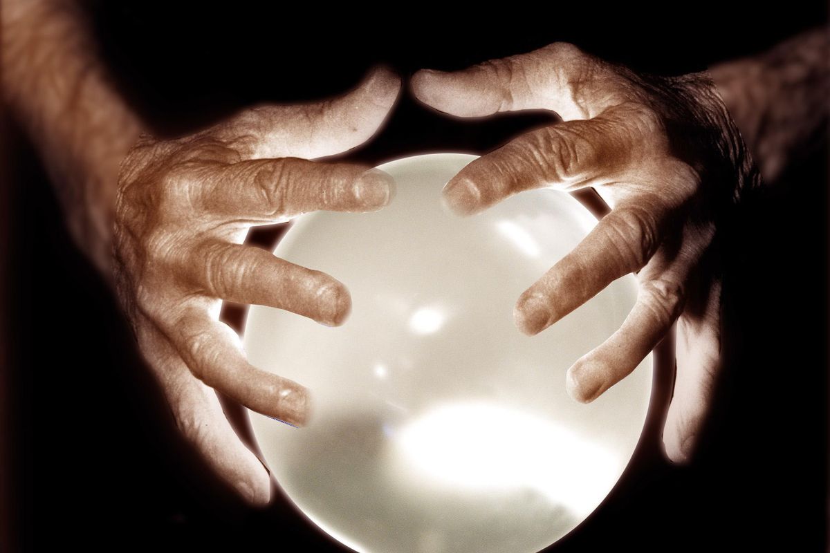 Photo-illustration shows a crystal ball with two hands. Financial planners unsur