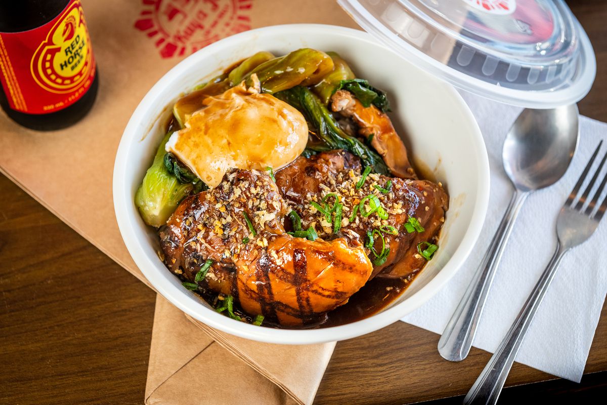 Boneless chicken thighs glazed in sweet soy sauce and topped with crushed peanuts go into a takeout bowl filled with bok choy and a poached egg.