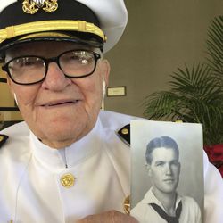 In this Monday, Dec. 5, 2016 photo, Jim Downing, 103, poses in a Navy uniform in Honolulu, with a photo of himself taken when he was about 20 years old. Downing is among a few dozen survivors of the Japanese attack on Pearl Harbor who plan to gather at the Hawaii naval base Wednesday, Dec. 7, 2016, to remember those killed 75 years ago. 