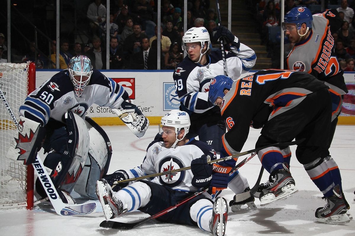 UNIONDALE, NY - APRIL 05: Grant Clitsome #24 of the Winnipeg Jets ties up Marty Reasoner #16 of the New York Islanders at the Nassau Veterans Memorial Coliseum on April 5, 2012 in Uniondale, New York.  (Photo by Bruce Bennett/Getty Images)
