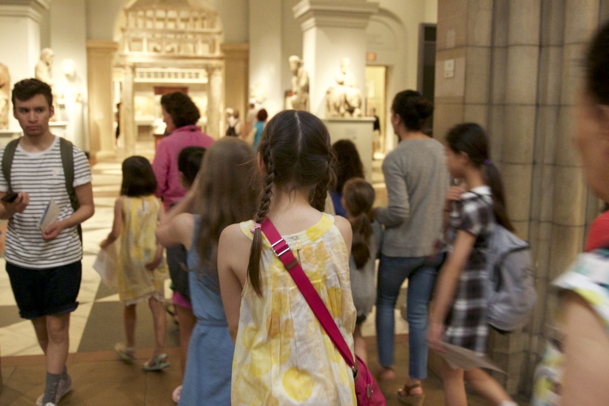 A child follows the docent through the Met
