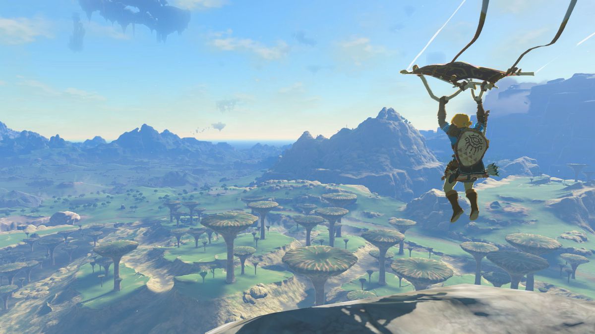 An image of Link soaring into a region of Hyrule with his glider. The land is peppered with stone geographical features that look like mushrooms and you can see mountains in the distance. 