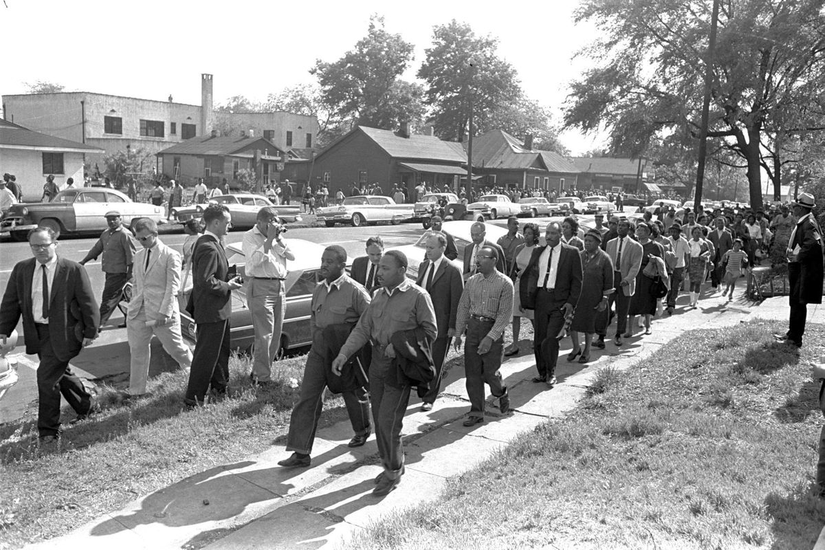Rev. Ralph Abernathy, left, and Rev. Martin Luther King Jr. lead a column of demonstrators as they attempt to march on Birmingham, Ala., city hall April 12, 1963. Police intercepted the group short of their goal. Rev. Jonathan McPherson, shown in a coat and tie two people behind King, in 2021 is urging protesters against racial injustice to “keep on keeping on.” 