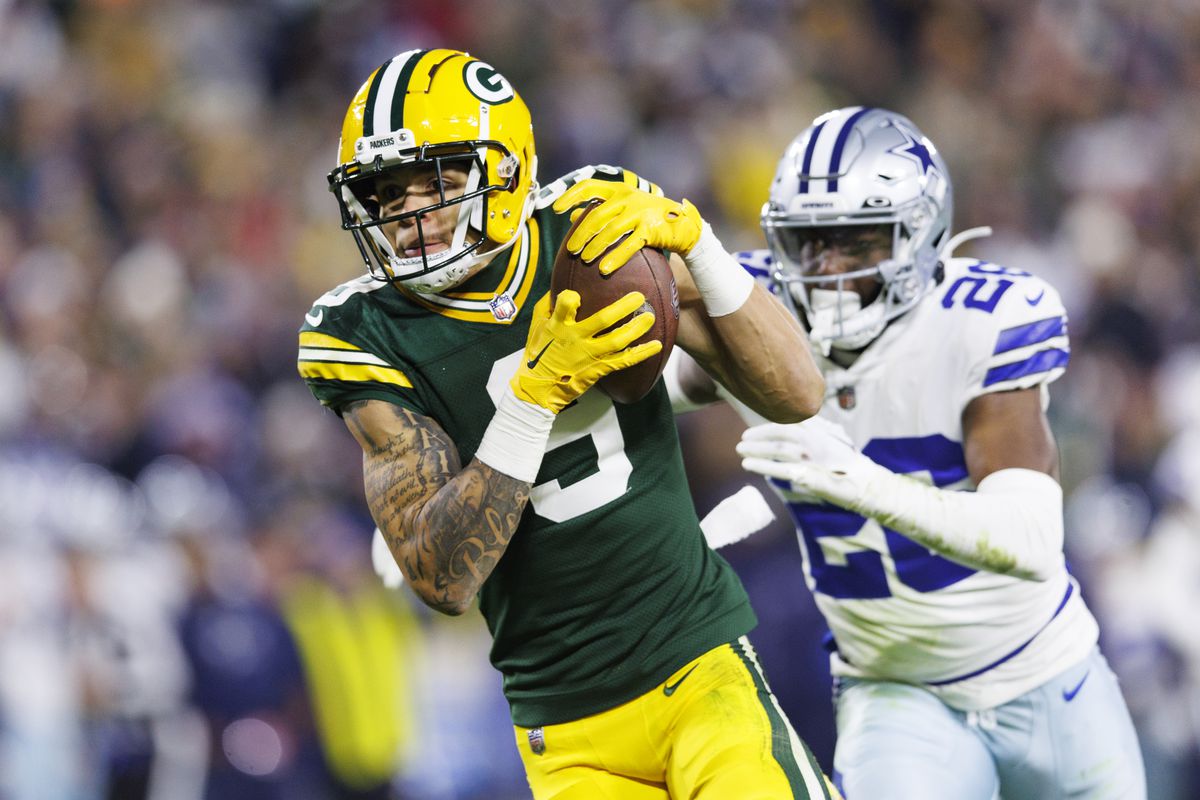 Green Bay Packers wide receiver Christian Watson rushes with the football in front of Dallas Cowboys cornerback DaRon Bland before scoring a touchdown during the fourth quarter at Lambeau Field.&nbsp;