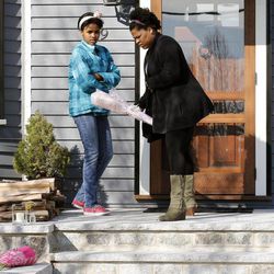 Two women place flowers on the doorstep of the Richard house in the Dorchester neighborhood of Boston, Tuesday, April 16, 2013. Martin Richard, 8, was killed in the Mondays bombings at the finish line of the Boston Marathon. The boy’s mother, Denise, and 6-year-old sister, Jane, were badly injured.  