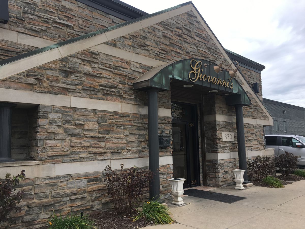 Giovanni’s restaurant has a stone exterior with columns and a green sign with gold writing.