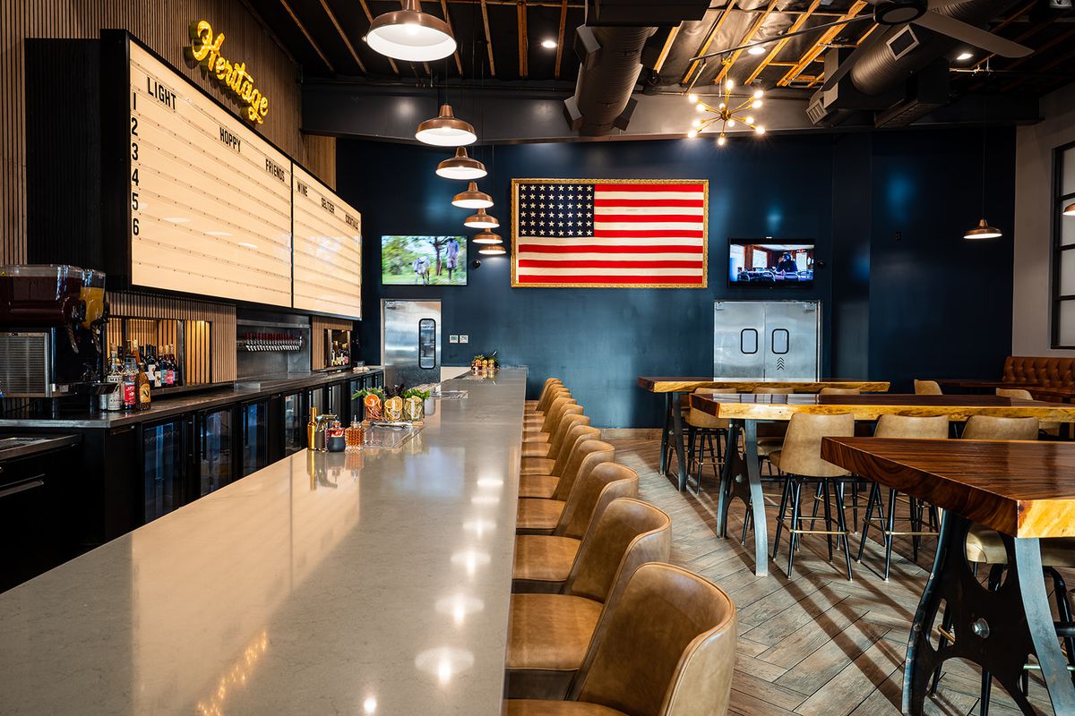 A long bar with an American flag on the wall.