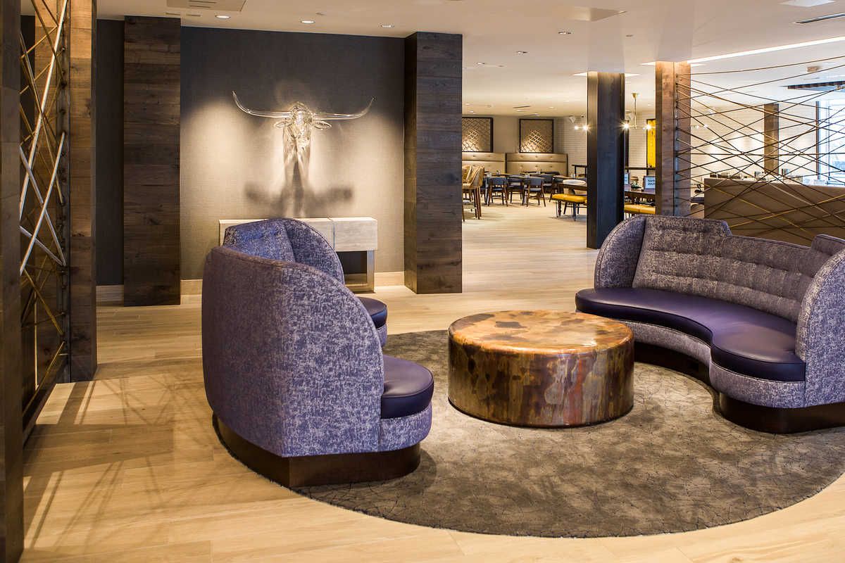 Hotel lobby with purple couches and a glass sculpture of a steer